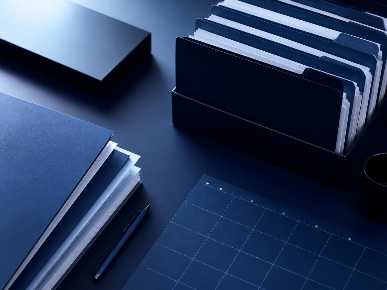 Organized tax document folders and a calendar grid on a dark desk